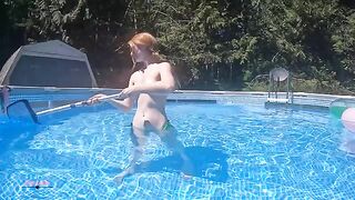 Redhead in red bikini does erotic floating in pool