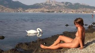 A hot chick is fucking on the riverbank without any clothes
