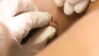 A girl plays with her new clitoral piercing
