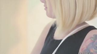 A blonde beauty with tattoos plays with her pussy in an intimate act
