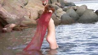 A girl with small boobs gets them wet while undressing outdoors