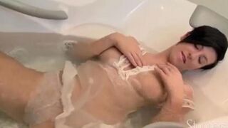 A lonely pregnant brunette woman caresses herself on the couch
