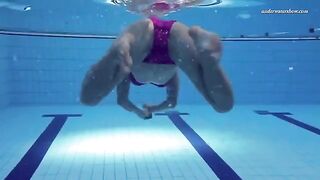 A hot naked girl is swimming in the pool with underwater shots