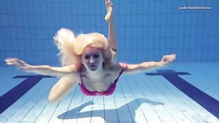 A hot naked girl is swimming in the pool with underwater shots