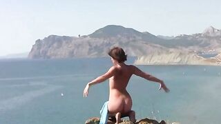A sexy girl poses naked on the beach and shows her curves