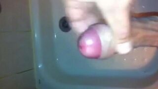 The kid caresses his dick under the shower jet