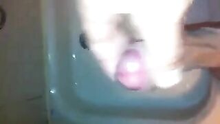 The kid caresses his dick under the shower jet