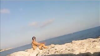 A girl is basking in the sun naked on the beach